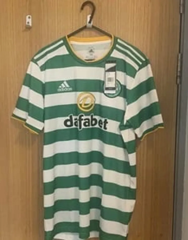 Green and white hooped Celtic football shirt on a hanger